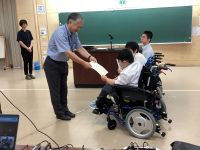 校長先生が生徒に認定書を授与している。