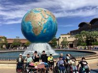 東京ディズニーシーの地球のモニュメントの前で１１人の生徒が並んでいる