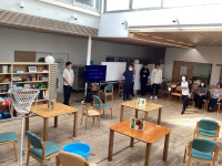 屋内の広々とした部屋で、数名の人々がビーンバッグ投げを行っている様子。屋内の広々とした部屋で、数名の人々がビーンバッグ投げを行っている様子。