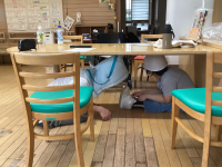 机の下に避難する様子。