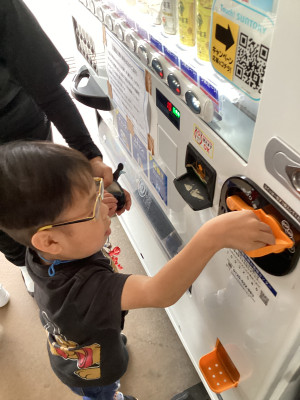 自動販売機にお金を入れています