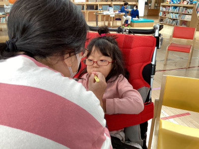 ② 先生がバギーに座っている児童の歯磨きをしている様子。