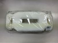 中央に四角い穴の開いたマスクが透明なビニール袋に入った状態で机の上に置かれている。右下にバーコードがあり、その下にNM-002-100の文字が見える。